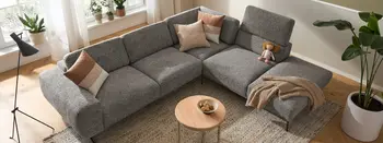Graues Ecksofa mit beigen Kissen